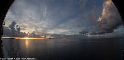 Sunset south of Bora Bora and a funnel cloud to the north (right)