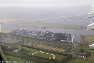 Wind generators and inland waterway with small freighter - final approach to Schiphol airport