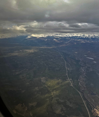 Klondike River and the highway below with snow-capped mountains in the distance