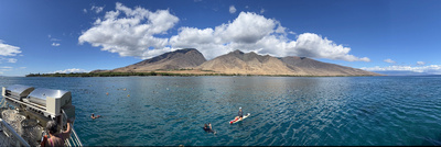 Snorkellers and lifeguards in the bay with the West Maui Mountains