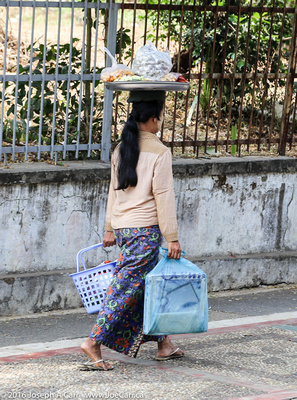 A woman carrying her shopping on her head