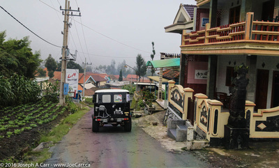 Jeeps descending through a village