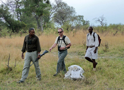 Joe and our guide Victor on a walking safari passing by an elephant skull