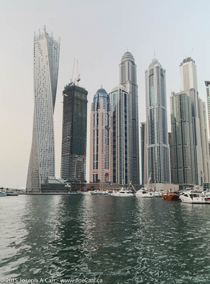 Cayan Tower beside other skyscrapers & moored boats