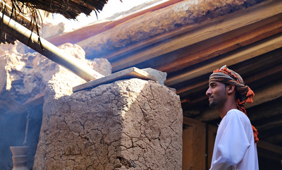 One of our young drivers in a traditional Omani house with smoke from a cooking fire