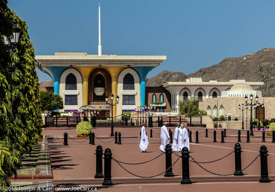 Omani men walk across the front courtyard of the Sultan's palace