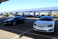 A white Model S 90D parked beside my Model S75D under the solar canopy