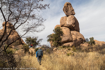 John, Lauri and Garry on the trail with a boulder formation ahead