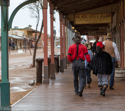 Locals dressed in period costumes walk by Big Nose Kate's Saloon
