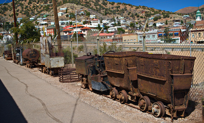 Rusty ore cars behind a trolley motor