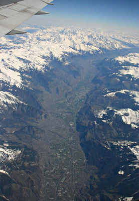 Snow-covered French Alps and deep valley with aircraft wing