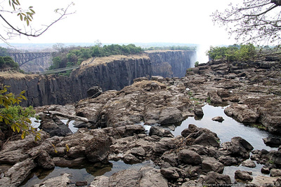 The dry Zambia side of the falls with the bridge & flowing Zimbabwe side visible behind