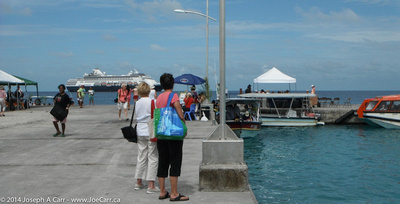 The pier with passengers, tenders, tour boats and shops, with Statemdam behind