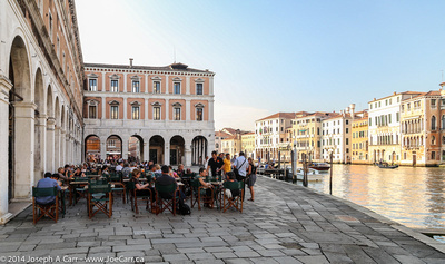 People dining beside the Grand Canal near the Rialto Bridge
