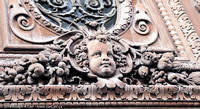 A cherub carved into a big door outside the Louve