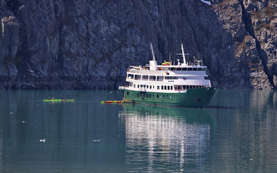 Safari Endeavour excursion boat near Lamplugh Glacier with kayakers