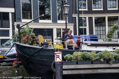 Man tending his flowers aboard his houseboat