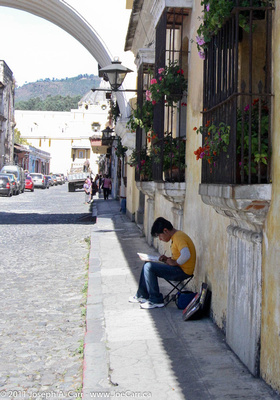 Street artist in front of Arch at El Carmen