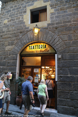 The group enters Trattoria Nella for dinner in Florence