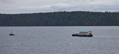 A building on a barge being towed north