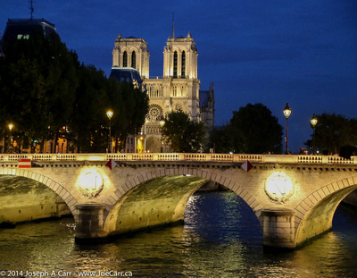 Notre Dame Cathedral and bridge on the Seine lit at night